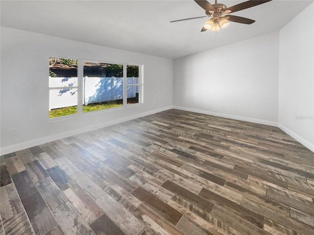 unfurnished room with ceiling fan, baseboards, and dark wood-style flooring