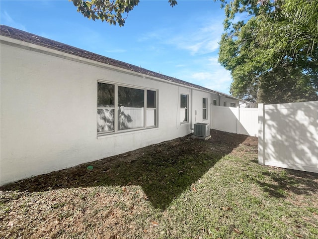 exterior space with cooling unit and fence