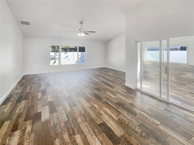 unfurnished living room with dark wood-type flooring, visible vents, baseboards, and a ceiling fan