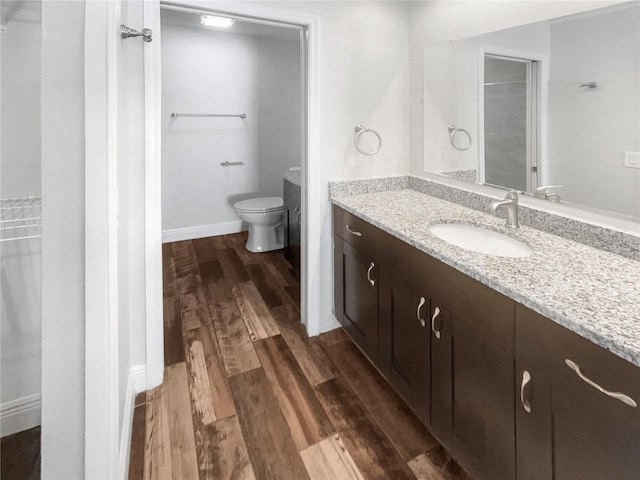 full bath featuring baseboards, vanity, toilet, and wood finished floors