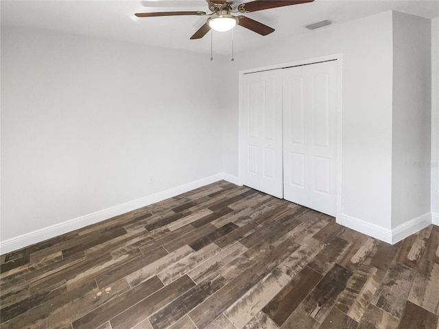 unfurnished bedroom featuring dark wood-type flooring, visible vents, and baseboards