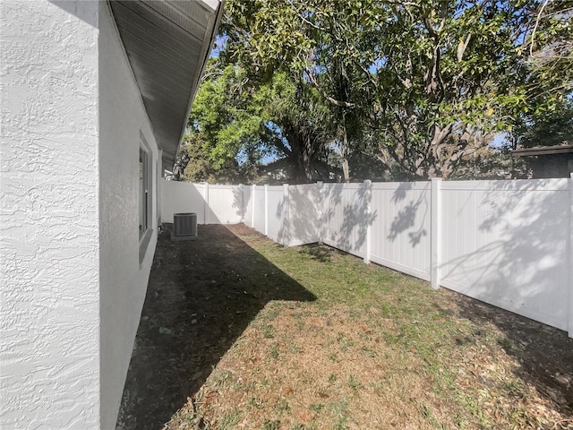 view of yard with a fenced backyard and central air condition unit