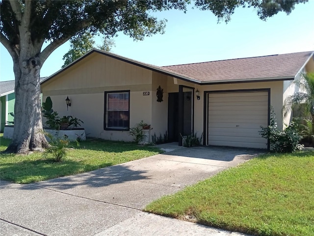 single story home with a shingled roof, a front yard, concrete driveway, and an attached garage