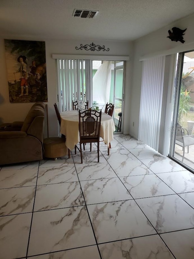 dining area featuring a textured ceiling and visible vents