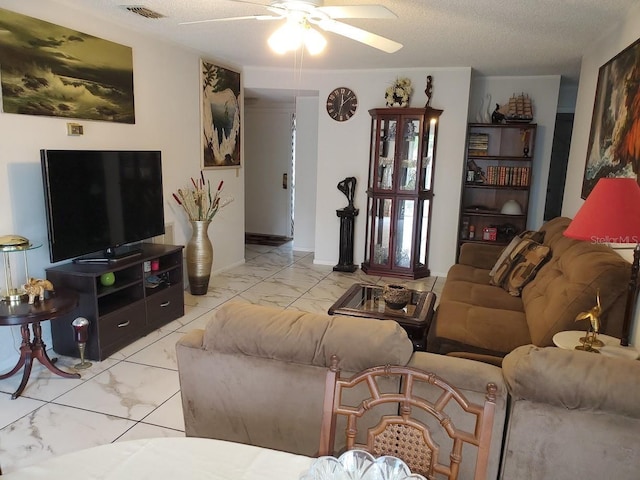 living room featuring a textured ceiling, marble finish floor, ceiling fan, and visible vents