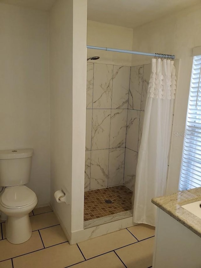 full bath with a stall shower, vanity, toilet, and tile patterned floors