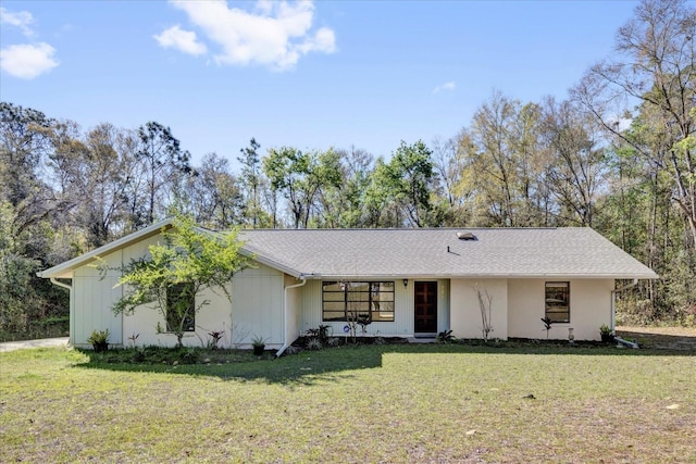 ranch-style house featuring a front yard and roof with shingles