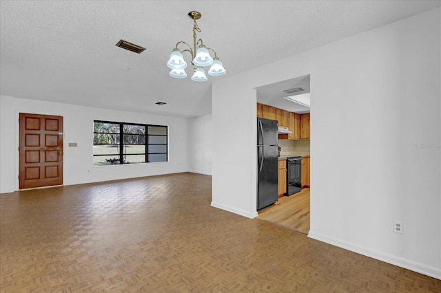 unfurnished living room with an inviting chandelier, visible vents, baseboards, and a textured ceiling