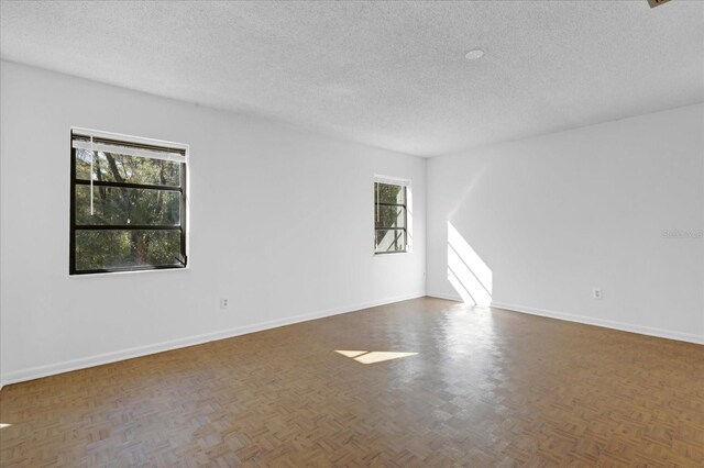 empty room with baseboards and a textured ceiling