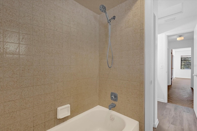 full bathroom with shower / bathing tub combination, wood finished floors, and baseboards