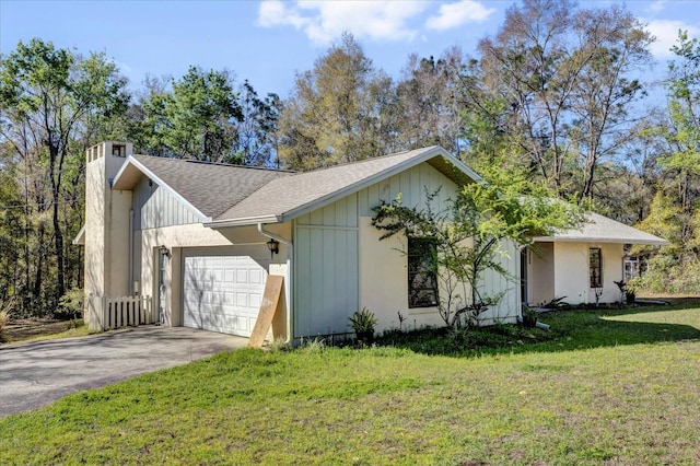 view of property exterior with an attached garage, a yard, driveway, board and batten siding, and a chimney