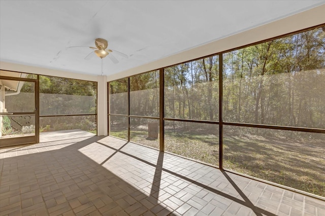 unfurnished sunroom with ceiling fan and a healthy amount of sunlight