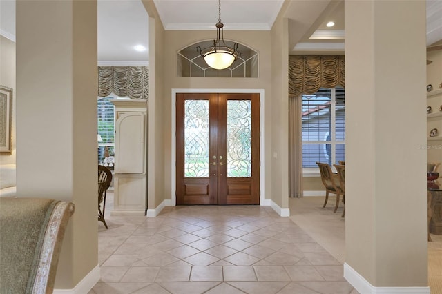 entryway featuring light tile patterned floors, baseboards, ornamental molding, a high ceiling, and french doors