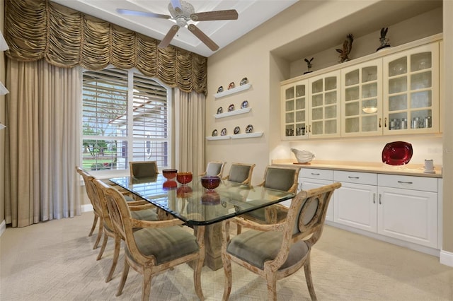 dining area with light carpet and a ceiling fan