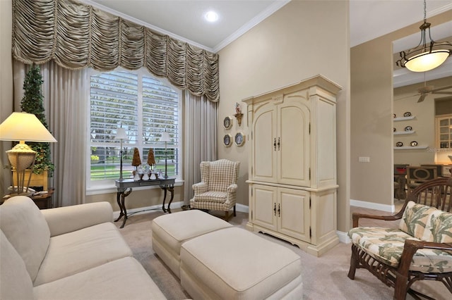 living area with crown molding, baseboards, a ceiling fan, and light colored carpet