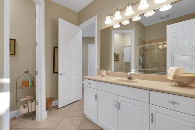 bathroom with a stall shower, tile patterned flooring, visible vents, and vanity