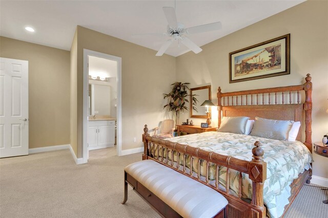 bedroom featuring recessed lighting, light colored carpet, ensuite bathroom, a ceiling fan, and baseboards