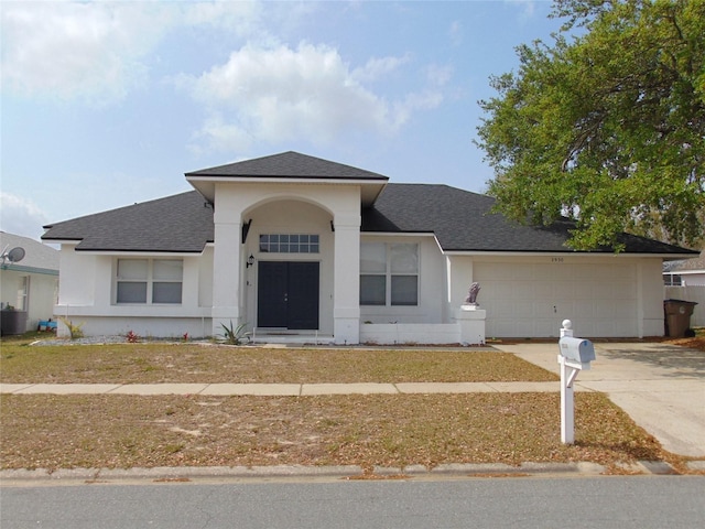 view of front of home featuring stucco siding, an attached garage, driveway, and a shingled roof