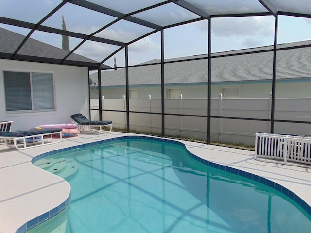 view of swimming pool featuring glass enclosure, a patio, and a fenced in pool