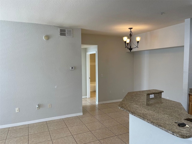 interior space with light tile patterned floors, baseboards, visible vents, an inviting chandelier, and a textured ceiling