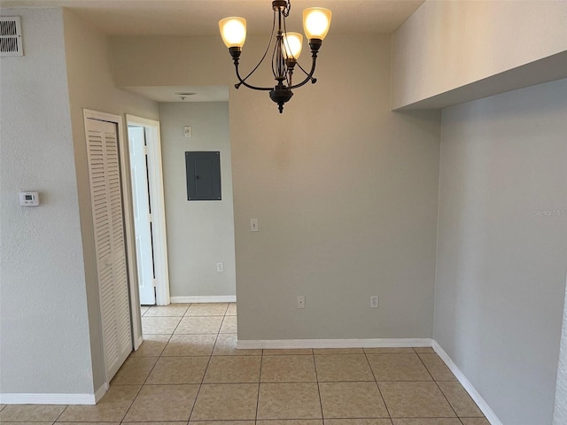 unfurnished dining area featuring electric panel, light tile patterned flooring, baseboards, and a chandelier