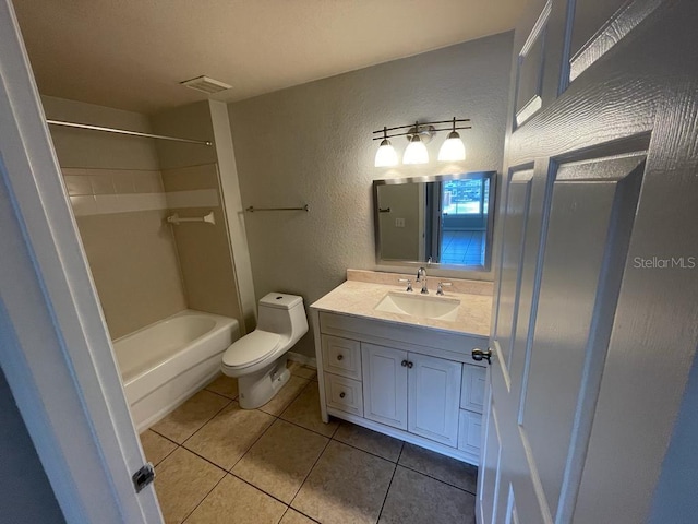 bathroom with visible vents, toilet, tile patterned flooring, vanity, and a textured wall