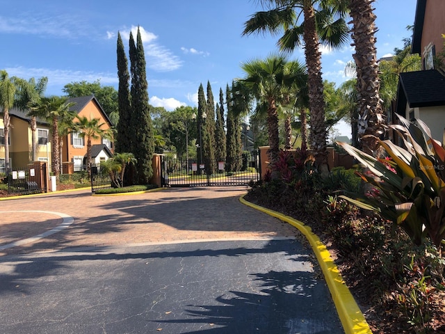 view of road featuring a gate, curbs, and a gated entry