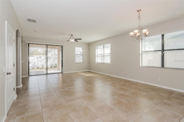 empty room with baseboards, visible vents, arched walkways, ceiling fan with notable chandelier, and light tile patterned flooring