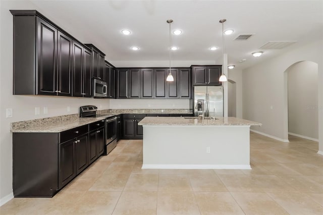 kitchen featuring visible vents, arched walkways, appliances with stainless steel finishes, pendant lighting, and a sink