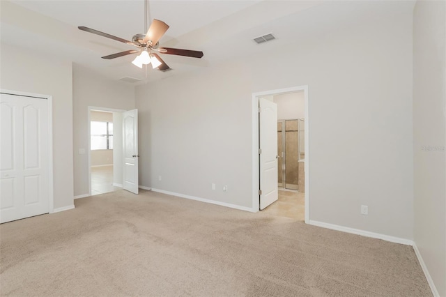 unfurnished bedroom with visible vents, light carpet, ceiling fan, ensuite bath, and baseboards