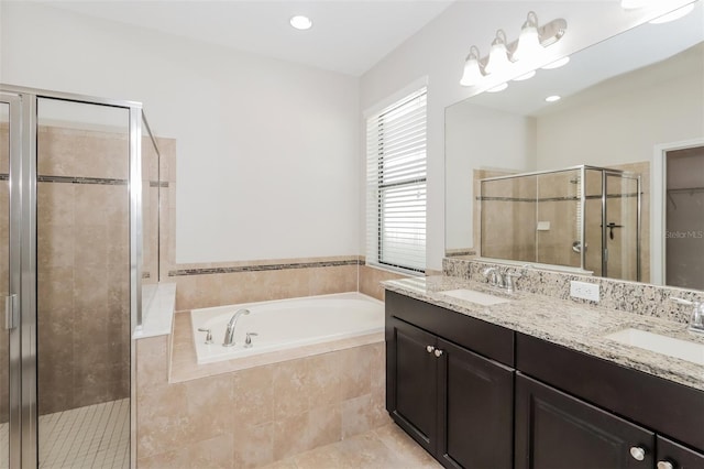 bathroom with a garden tub, double vanity, a sink, and a shower stall