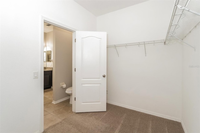 walk in closet featuring light carpet and light tile patterned floors