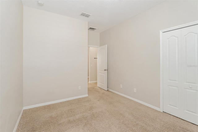 unfurnished bedroom with a closet, baseboards, visible vents, and carpet flooring