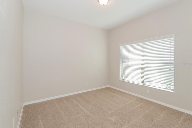 spare room featuring carpet flooring and baseboards