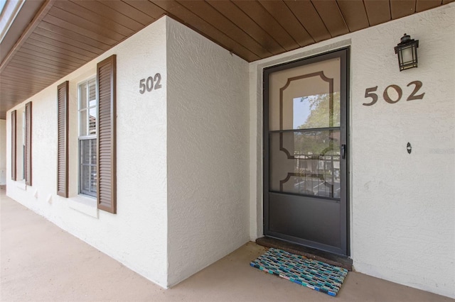 view of exterior entry with stucco siding