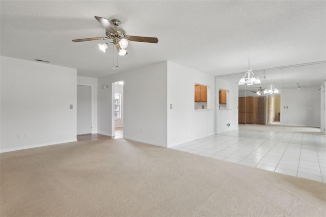 unfurnished living room featuring visible vents, light carpet, light tile patterned floors, ceiling fan with notable chandelier, and a textured ceiling