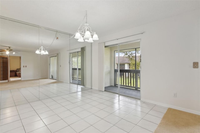 empty room featuring baseboards, light tile patterned flooring, and ceiling fan with notable chandelier