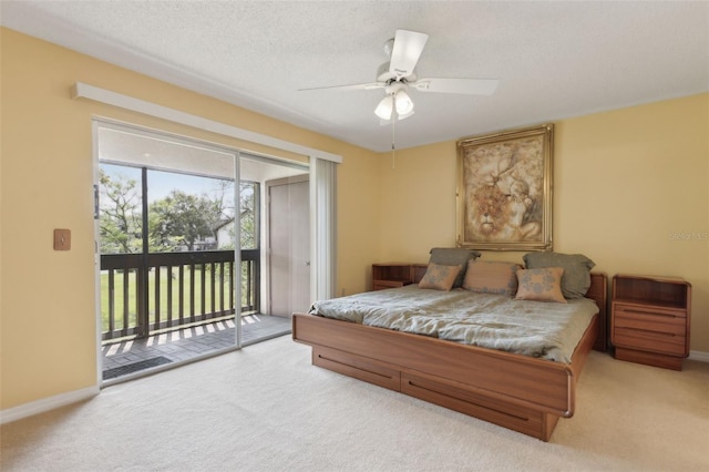 bedroom featuring access to exterior, a textured ceiling, baseboards, and carpet