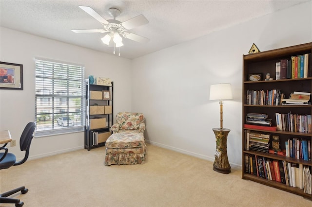 office space with carpet flooring, a textured ceiling, baseboards, and a ceiling fan