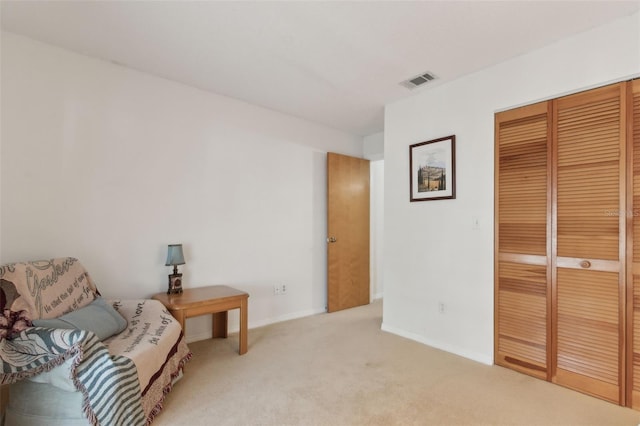 living area with light carpet, visible vents, and baseboards