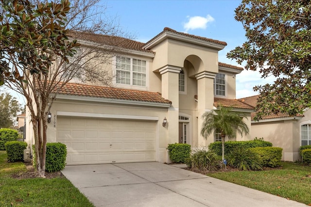 mediterranean / spanish home with an attached garage, a tile roof, concrete driveway, and stucco siding