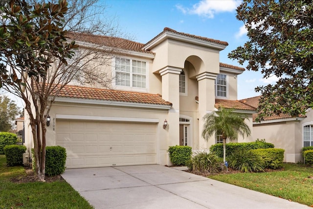 mediterranean / spanish house with a tile roof, stucco siding, and concrete driveway