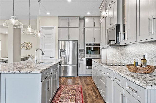 kitchen featuring appliances with stainless steel finishes, dark wood-style flooring, a sink, and gray cabinetry