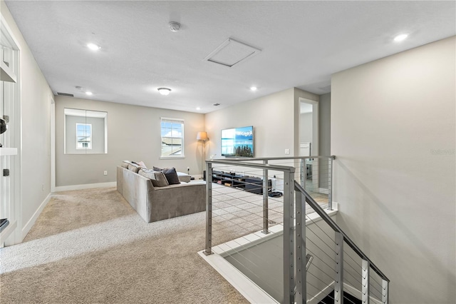 hall with carpet floors, recessed lighting, attic access, an upstairs landing, and baseboards