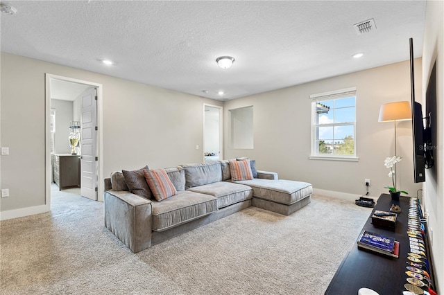 carpeted living area with a textured ceiling, recessed lighting, visible vents, and baseboards