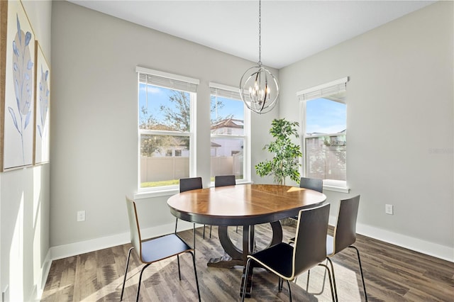 dining space featuring an inviting chandelier, baseboards, and wood finished floors