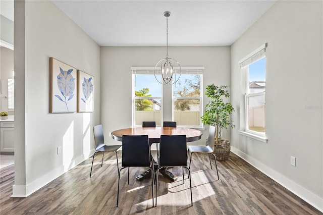 dining room featuring baseboards, wood finished floors, a wealth of natural light, and an inviting chandelier