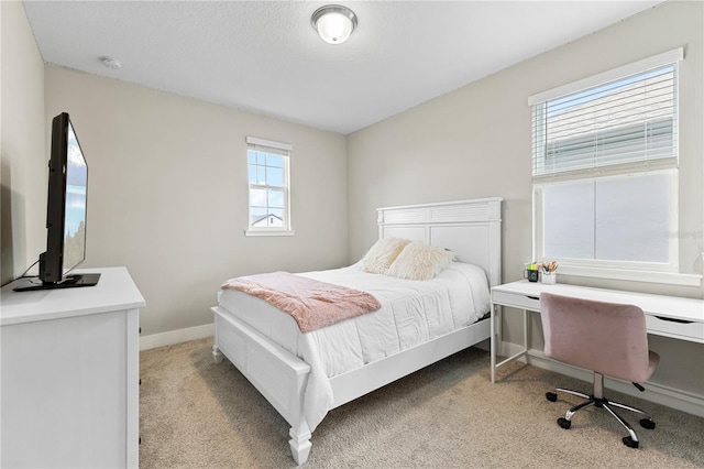 bedroom featuring light carpet and baseboards