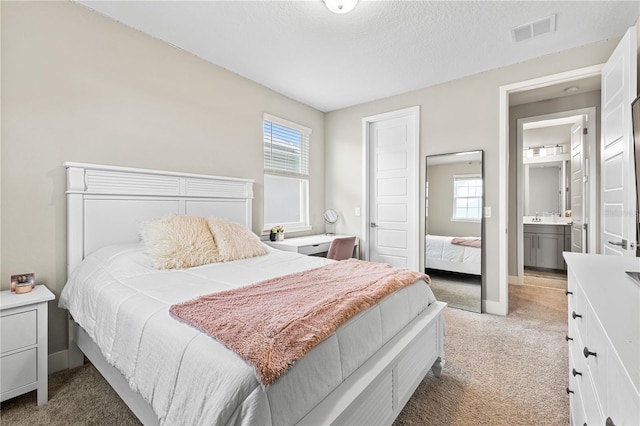 bedroom with a textured ceiling, a sink, visible vents, baseboards, and carpet