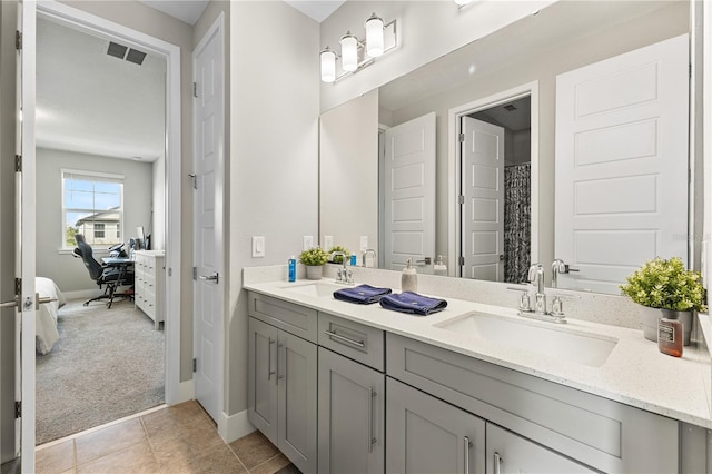 full bath with double vanity, a sink, visible vents, and connected bathroom